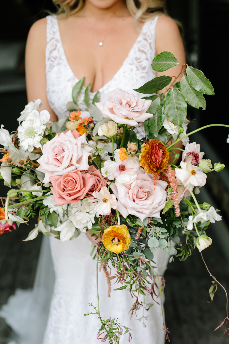 Asymetrical bouquet with greenery, garden roses, ranunculas