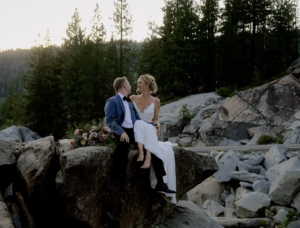 Bride and groom sitting on boulders at their wedding in Lake Tahoe