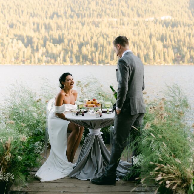 Couple enjoying dinner on a pier in Donner Lake with greenery decorating the background in Lake Tahoe